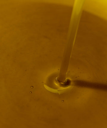 Close-up of a regenrative avocado oil being poured into a container.